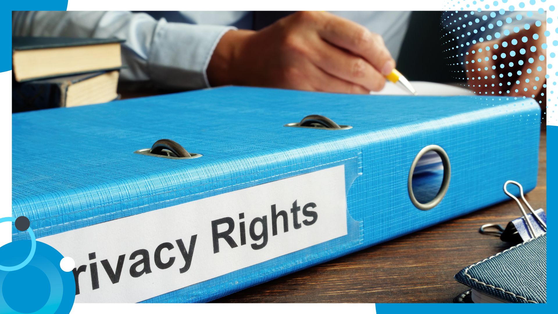 A blue binder labeled 'Privacy Rights' on a wooden desk, with a person in the background holding a pen, symbolizing data protection and regulatory compliance.